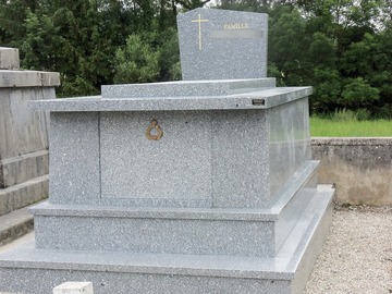 Monument funéraire en granit et croix dorée